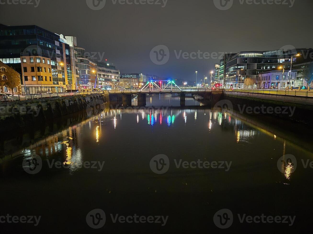 Cityscape at Dusk with Waterway and Bridge Reflections photo