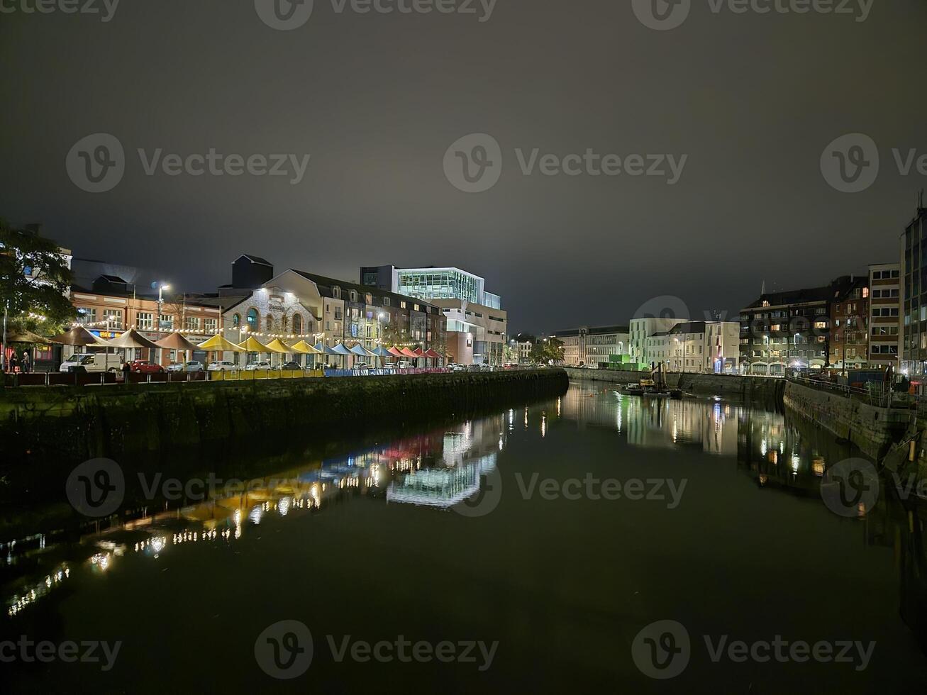 Midnight Cityscape Reflection with Tower Blocks and Clouds Over Lake photo