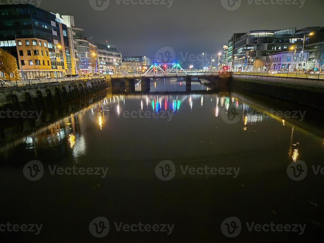 Cityscape at Dusk with Bridge Over Lake and Reflections in Water photo