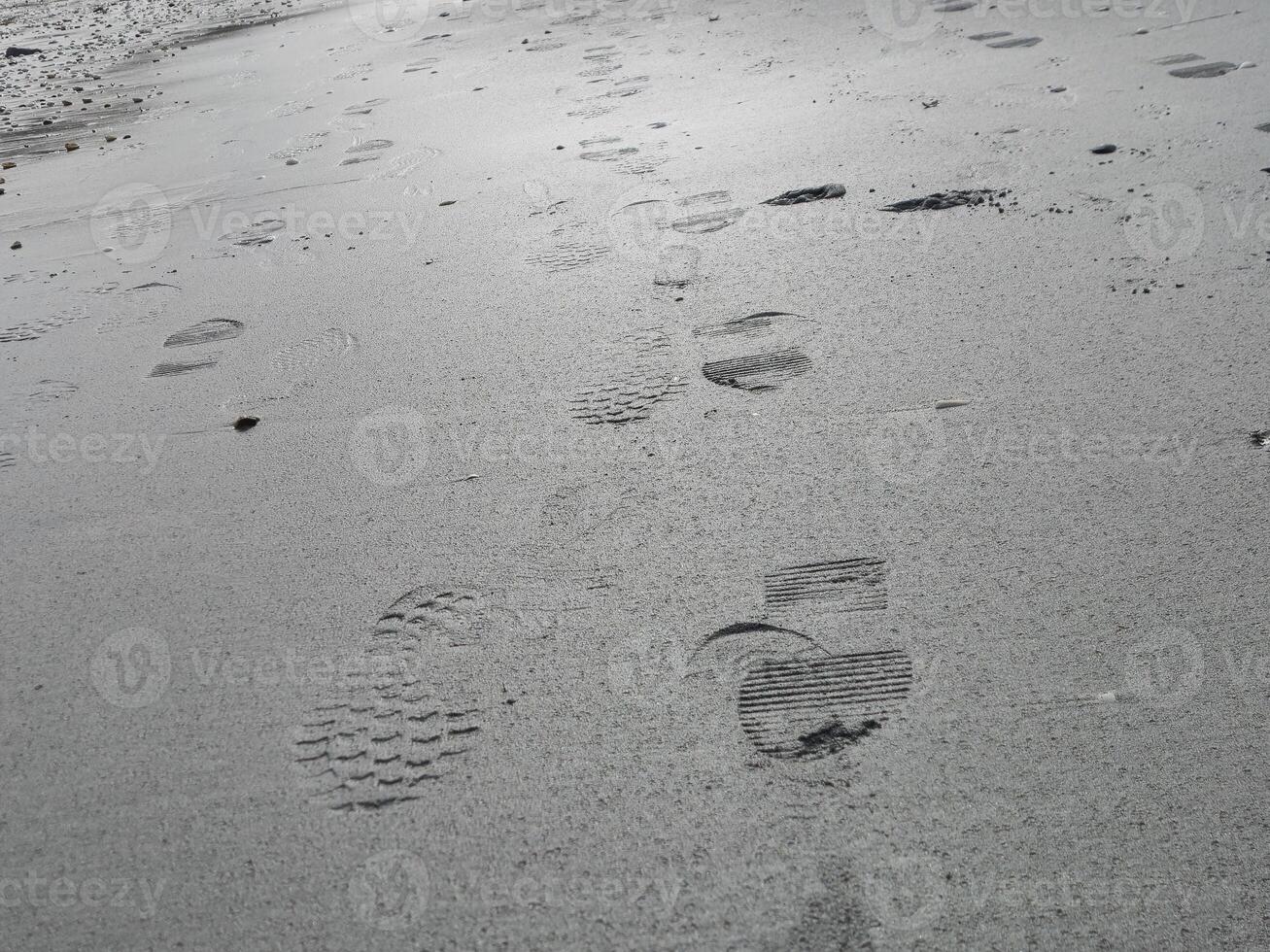 Foot prints on sea side beach background photo