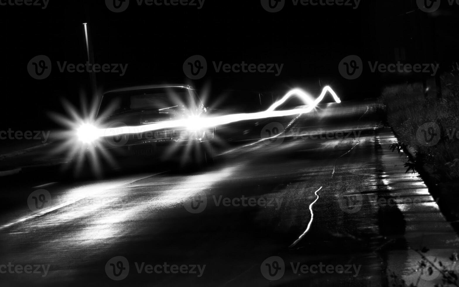 Sleek Car Headlamp Illuminating Asphalt on a Nighttime Drive photo