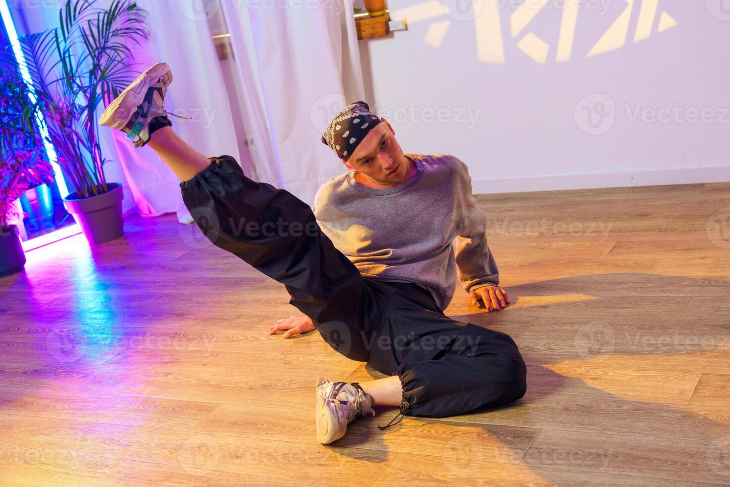 A dancer practices a move on the floor of a dance studio photo