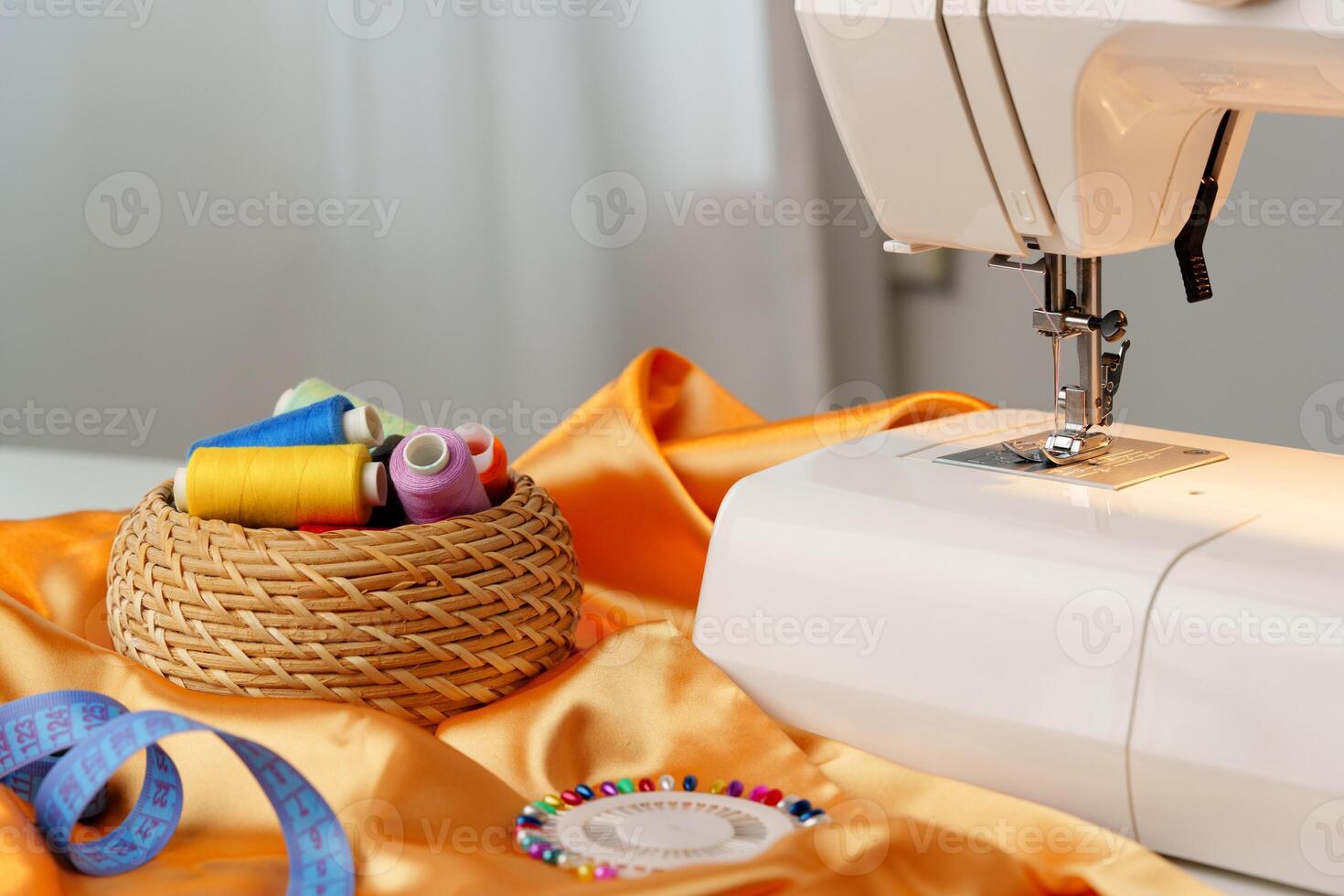 Sewing machine in use on a wooden table, stitching a light fabric in a well-lit indoor workspace photo