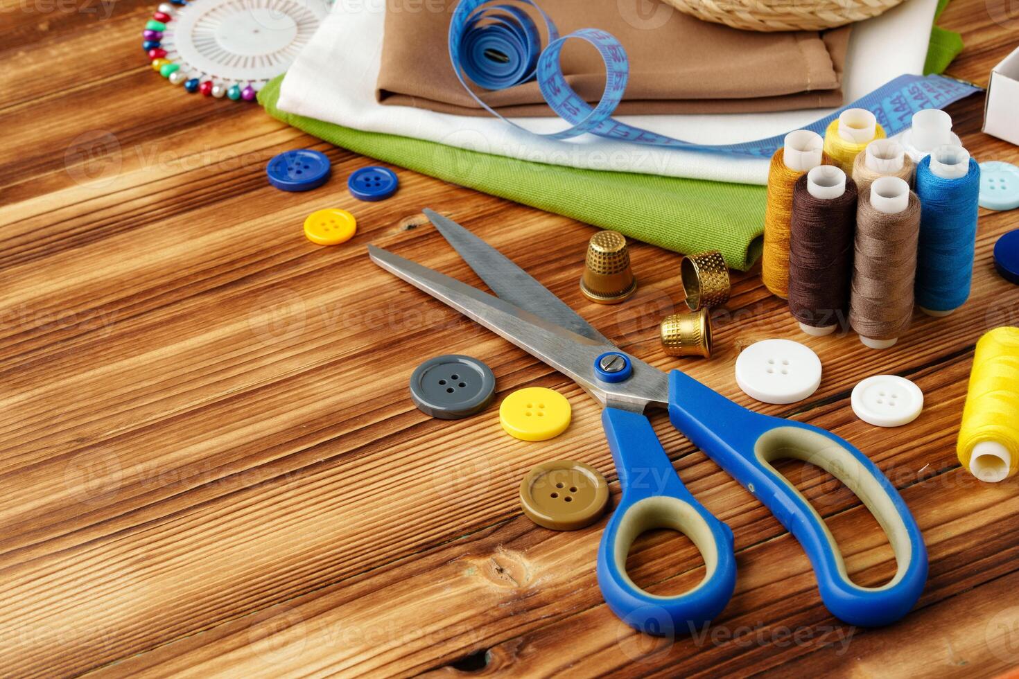 Crafting tools and materials arranged on a wooden table for sewing projects photo