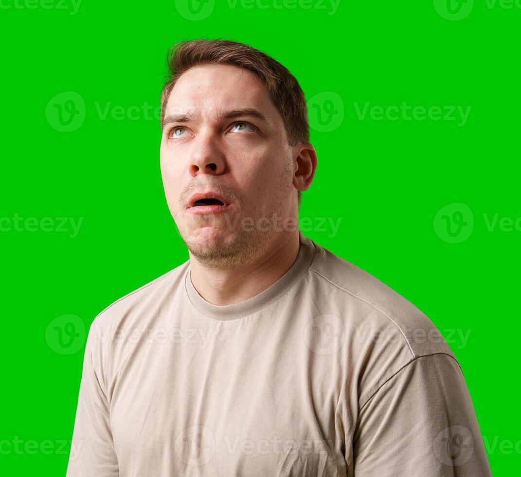 Man making a humorous expression against a bright green background photo