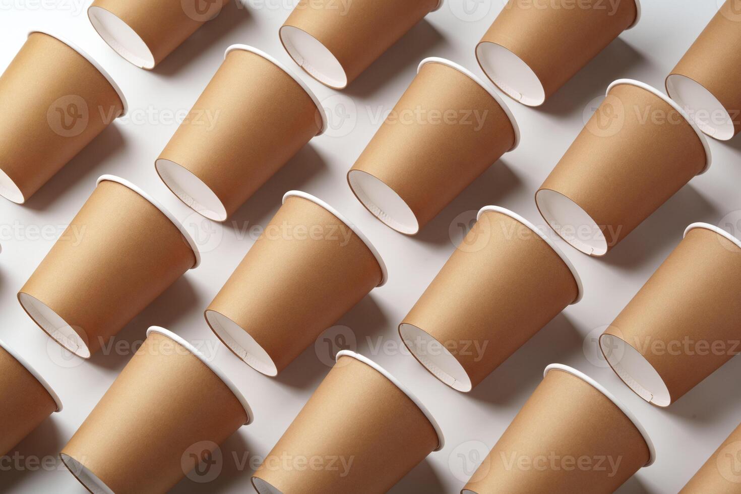 A collection of disposable paper cups arranged in a repeating pattern on a light background photo