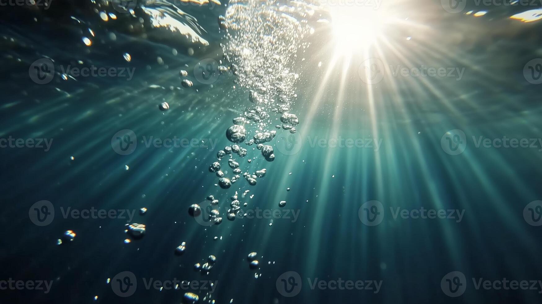 Sunlight beams create a dazzling underwater experience with bubbles rising in clear water photo