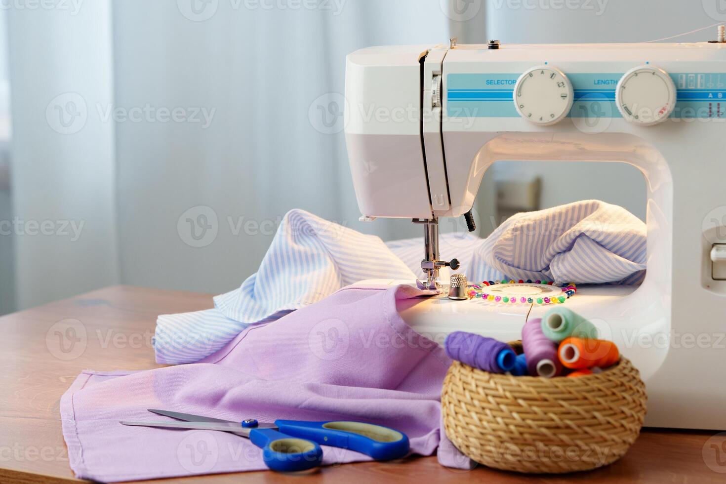 Sewing machine in use on a wooden table, stitching a light fabric in a well-lit indoor workspace photo