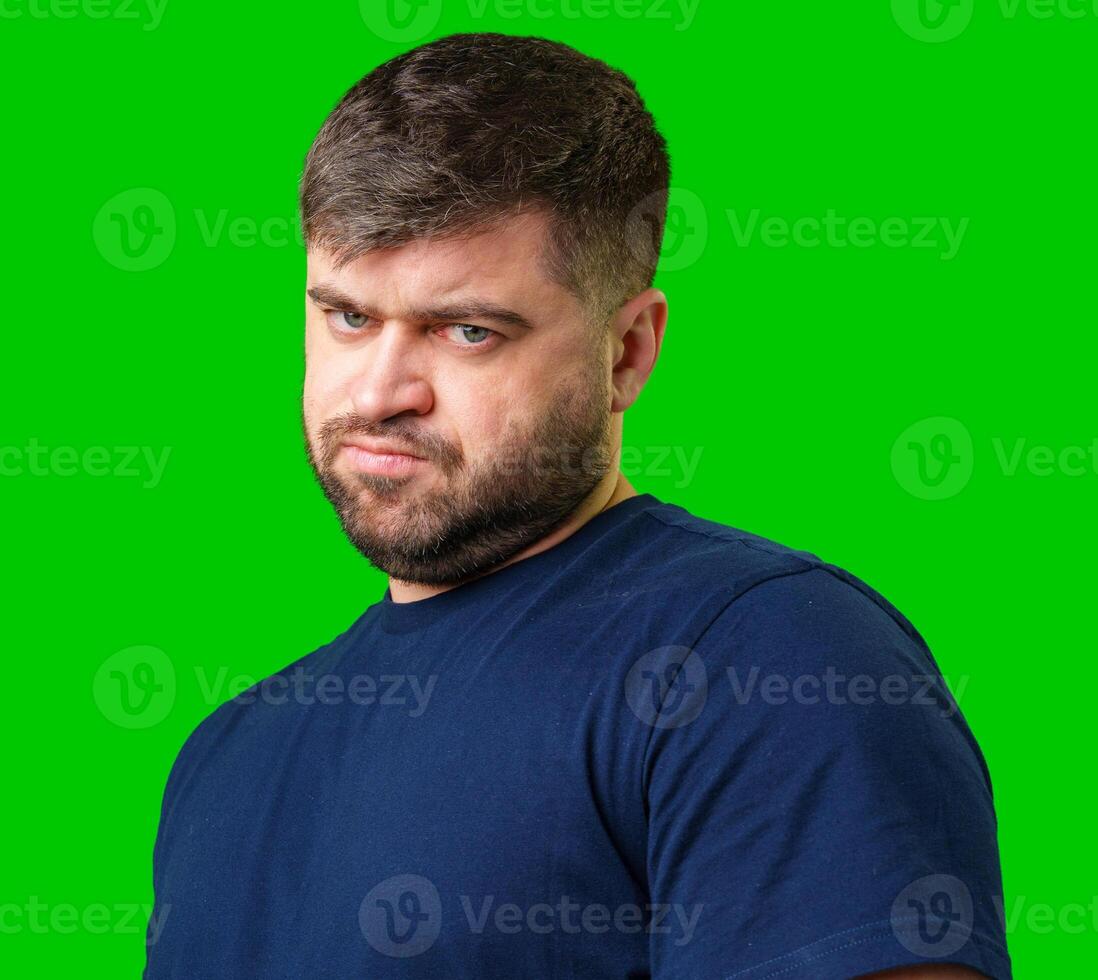 Man expressing confusion with crossed arms in front of a bright green background photo