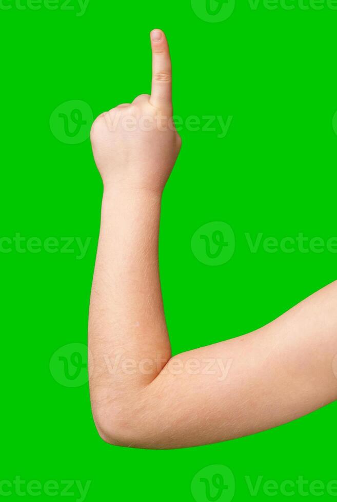 A hand raised with an index finger pointing upwards against a bright green background photo