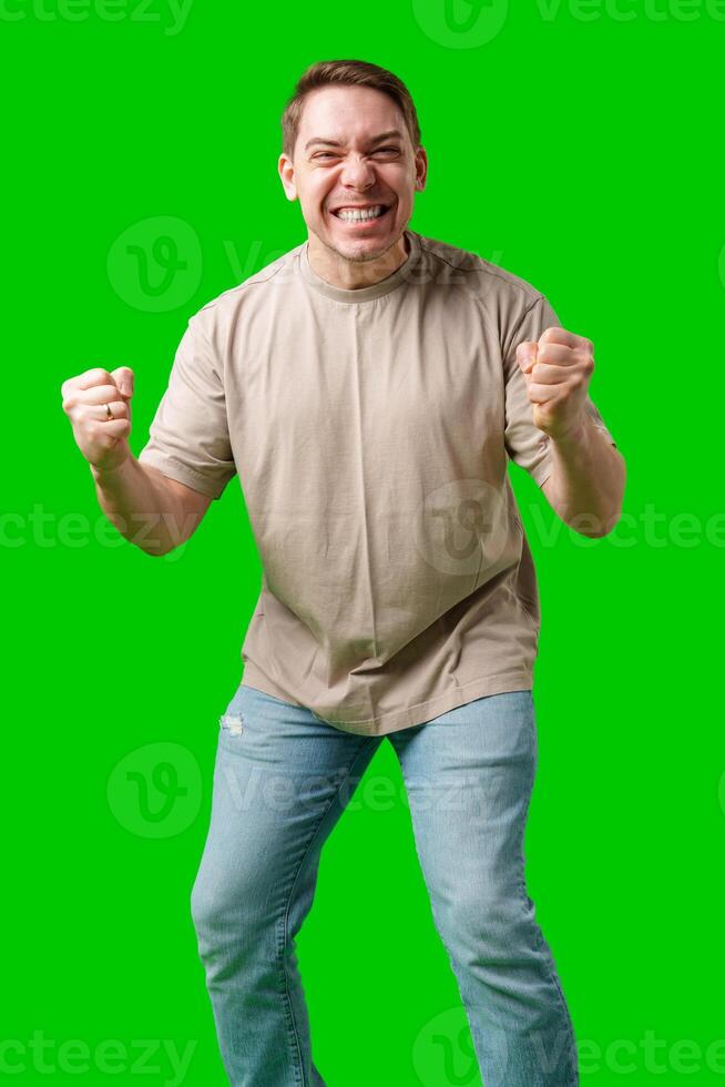 Man celebrating with a confident smile and raised fist against a bright green background photo