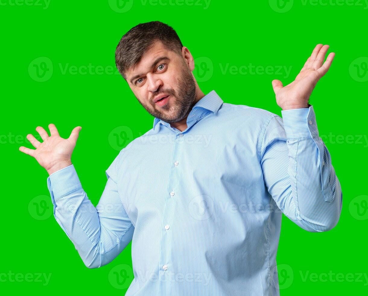A man playfully posing with a quirky expression against a bright green background photo