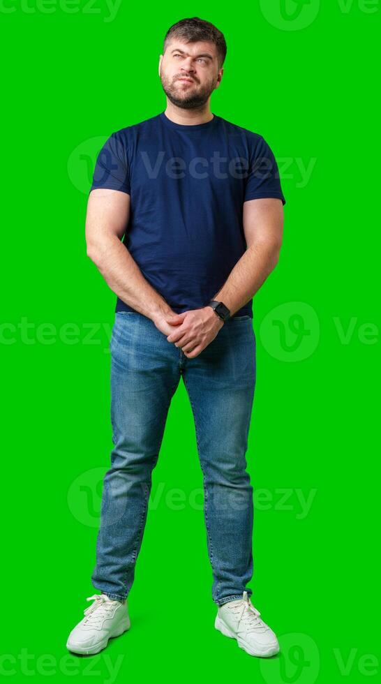 Man standing with a thoughtful expression in a casual outfit against a green background photo