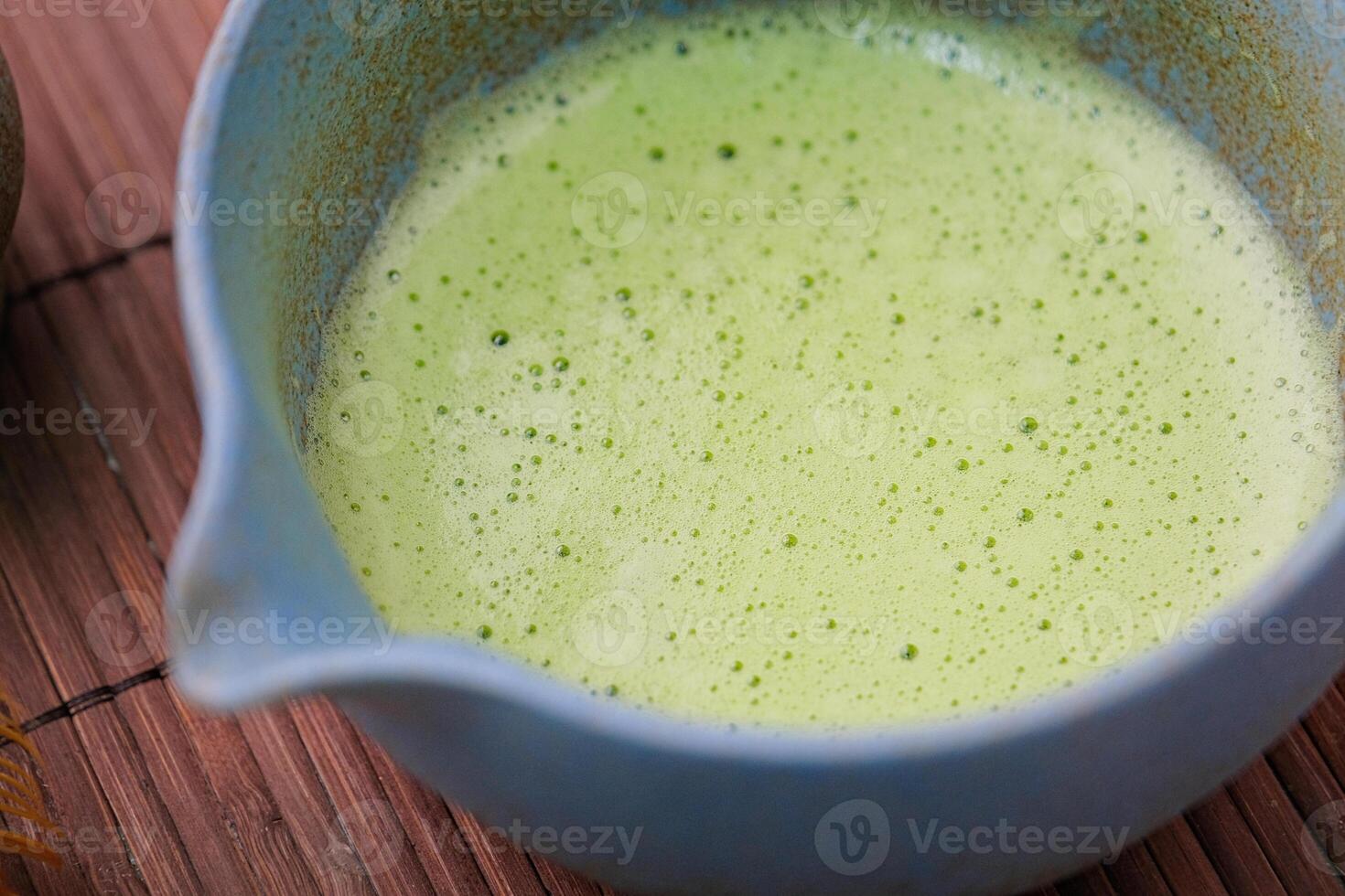 closeup of green matcha tea whipped in the tea bowl photo