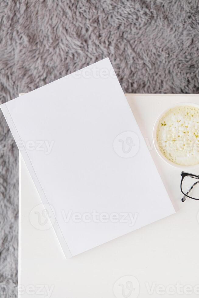 blank magazine mockup on coffee table with green matcha tea near window photo