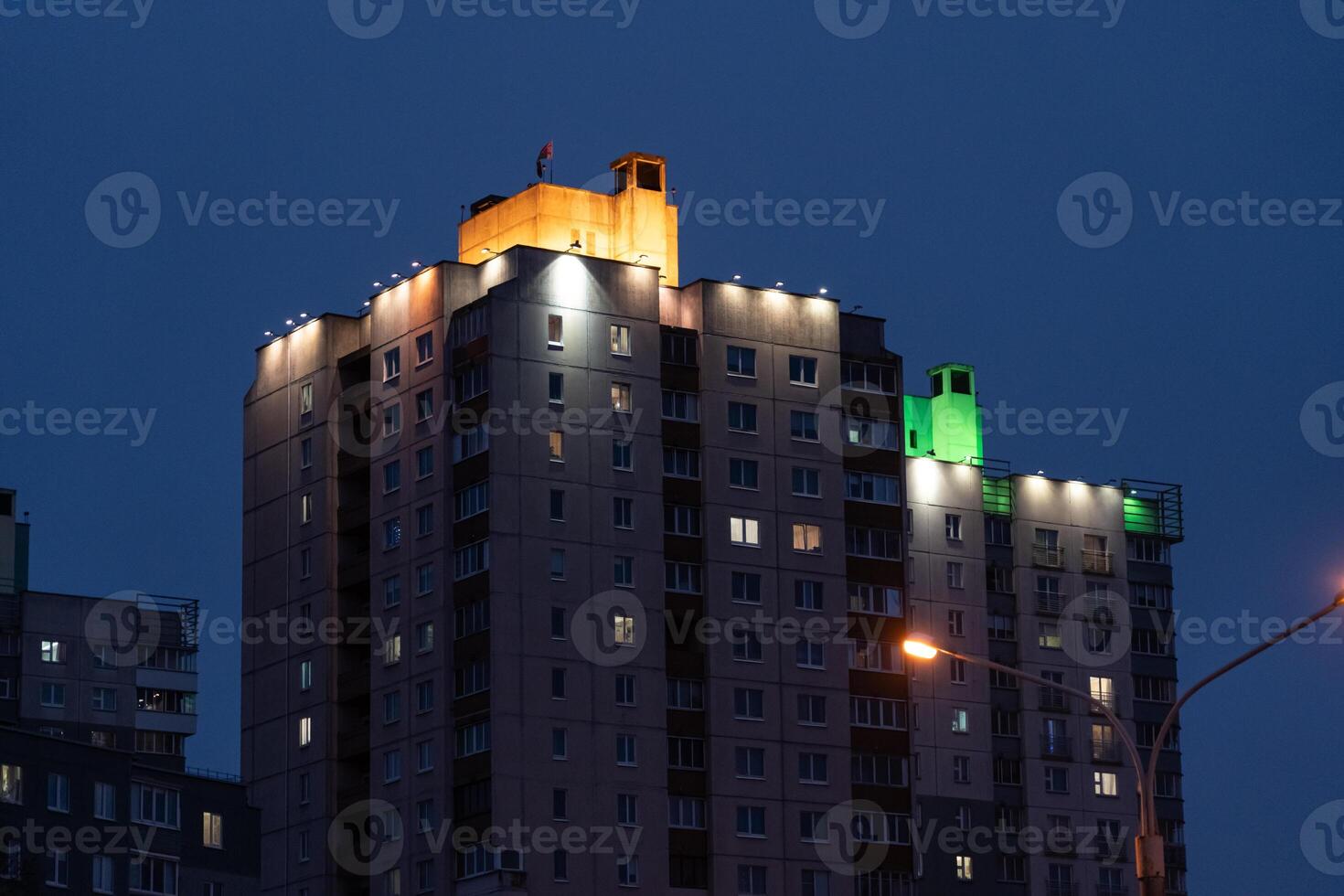 Illuminated panel, multi-storey buildings in the distance. An evening in Minsk photo