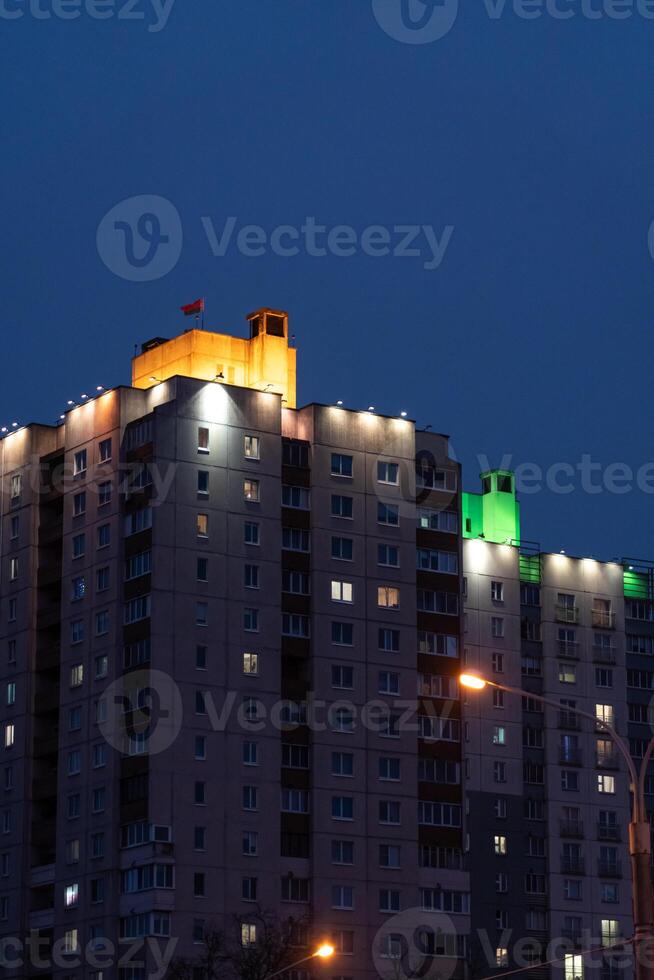 Illuminated panel, multi-storey buildings in the distance. An evening in Minsk photo