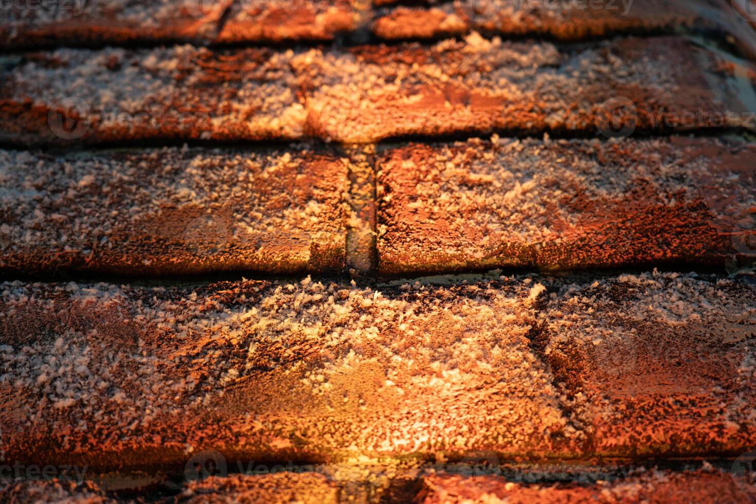 A brick wall in the snow is illuminated from below. Christmas background photo
