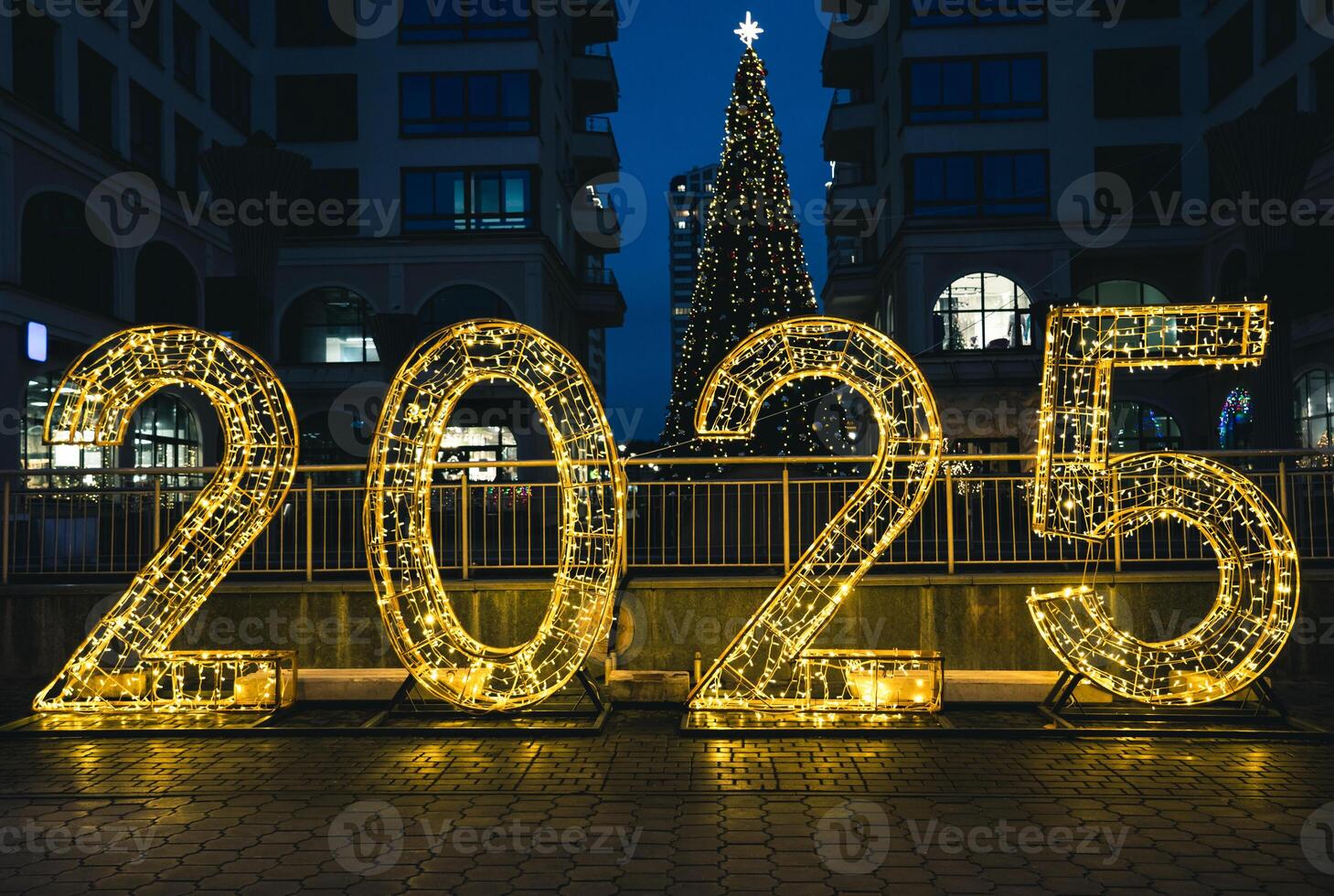 The number 2025 is made of a garland, in the center of the city. New Year's mood photo