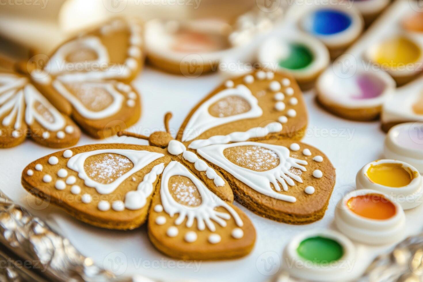 Small gingerbreads in butterfly form with white icing for painting and a palette with small edible paints for a child. photo