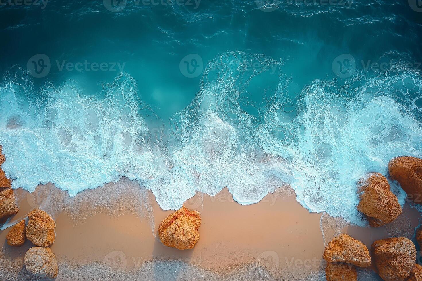 Turquoise ocean waves crashing on sandy beach with rocks, aerial view photo