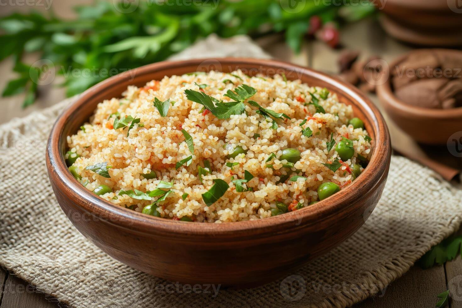 Bowl of delicious couscous with peas, herbs, and spices on rustic table photo