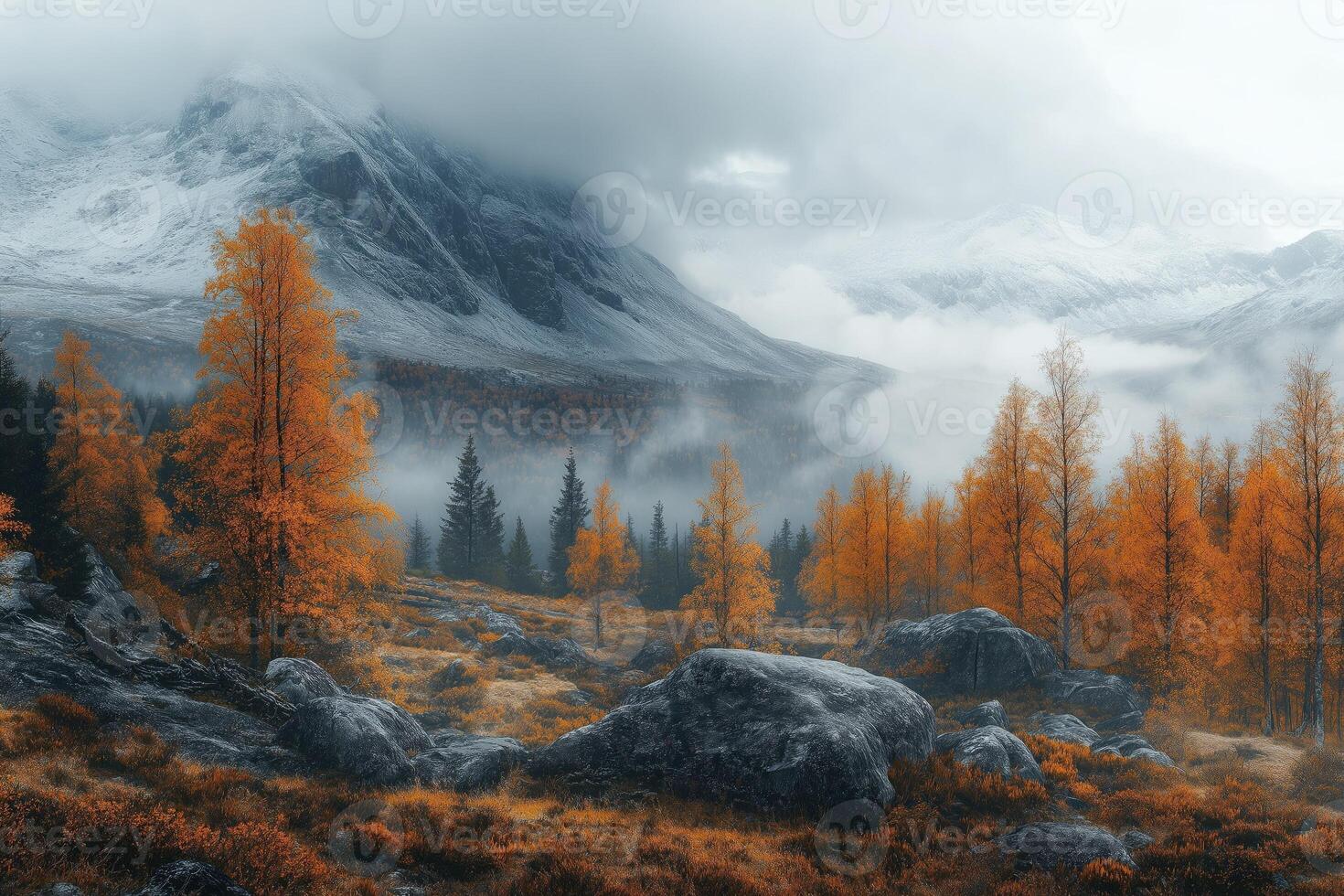 Fog rolling over snowy mountain peaks in autumn landscape photo