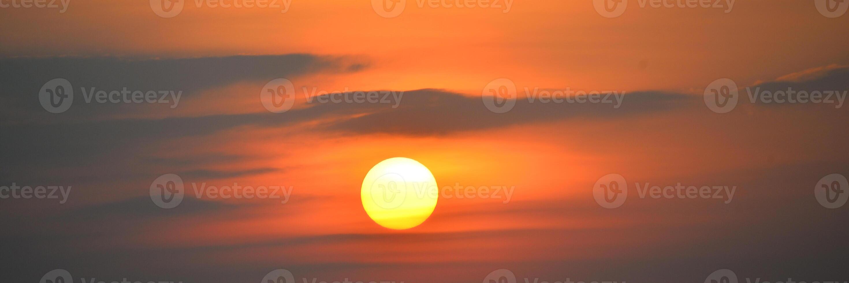 Stunning Sunset with Vibrant Orange and Yellow Hues Over a Tranquil Horizon Captured in a Serene Evening Sky photo