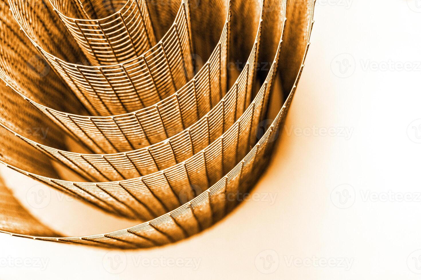 Abstract spiral metal coiled wire mesh with orange brown grid pattern, geometric symmetry, minimalist design for industrial construction, diy concepts. Isolated on white background. Copy space photo