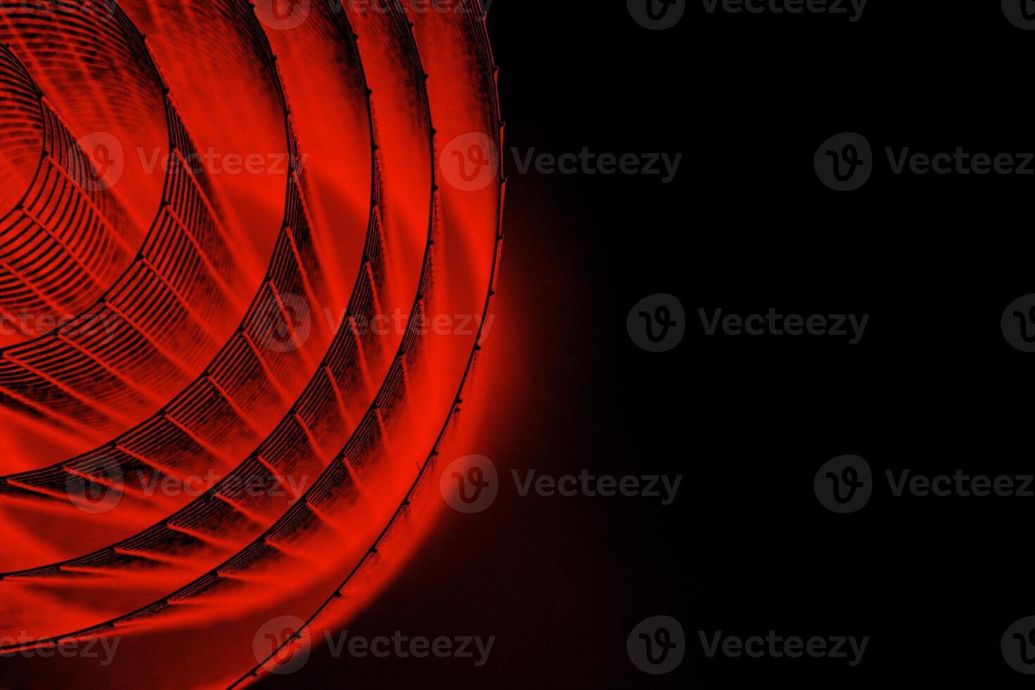 Abstract spiral with glowing red wire texture against a black background, symbolizing color contrast, energy, motion, industrial and futuristic design concepts. Copy space photo