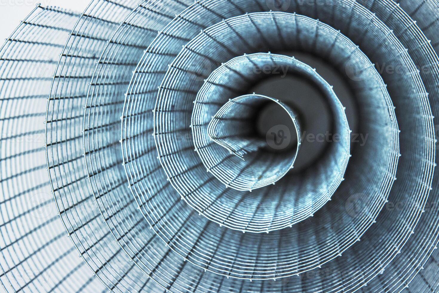 Abstract spiral metal coiled wire mesh with grid pattern, geometric symmetry, modern minimal design for industrial construction, diy, architectural concepts. Isolated on white background. Copy space photo