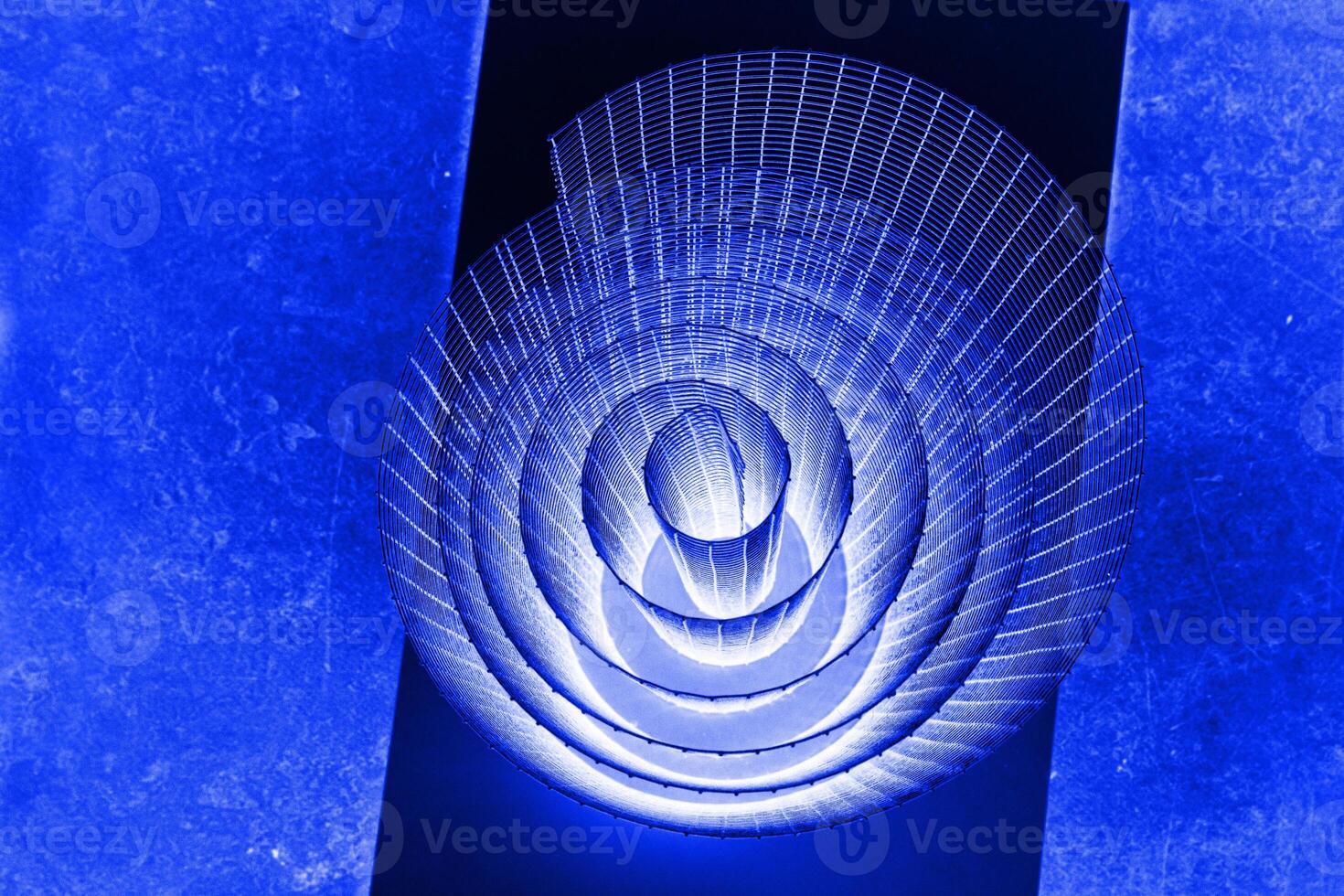 Abstract spiral with glowing blue, lilac, violet, purple tones and wire texture against a black background, symbolizing energy, motion, industrial and futuristic design concepts. Copy space photo