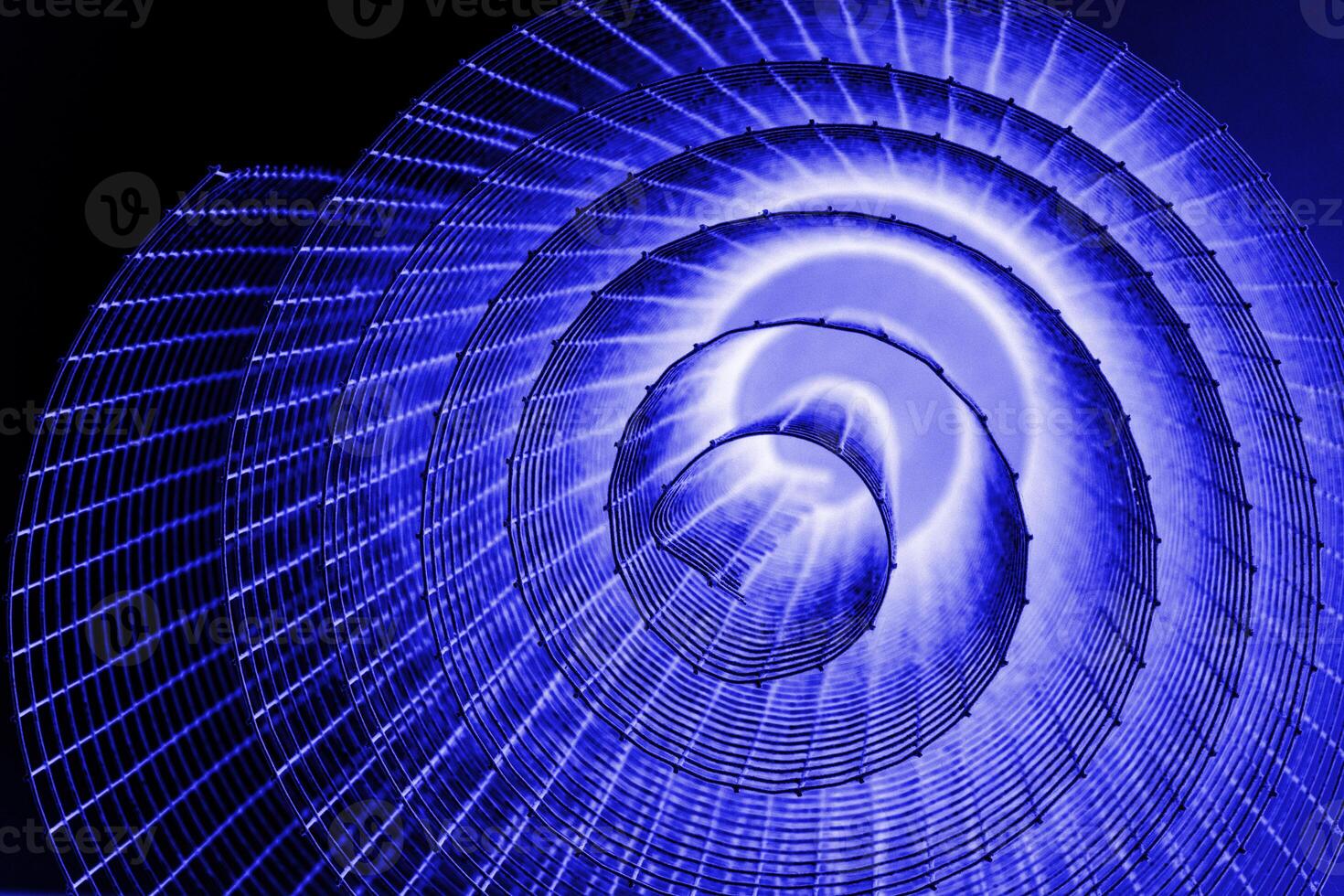 Abstract spiral with glowing blue, lilac, violet, purple tones and wire texture against a black background, symbolizing energy, motion, industrial and futuristic design concepts. Copy space photo