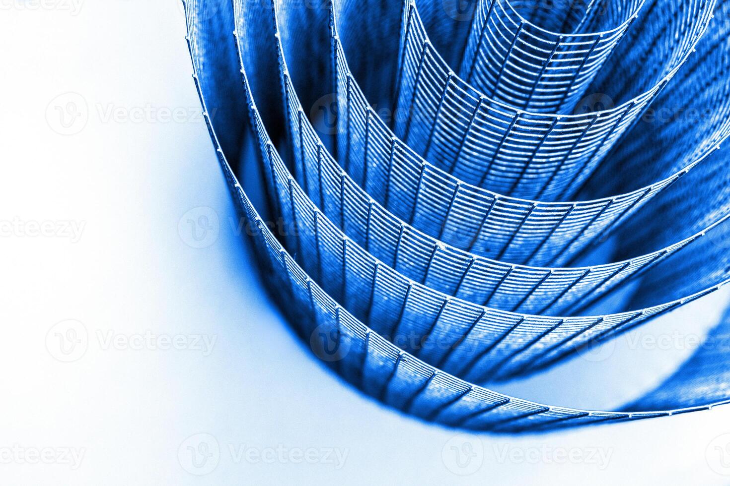 Abstract spiral metal coiled wire mesh with blue grid pattern, geometric symmetry, minimalist design for industrial construction, diy, architectural concepts. Isolated on white background. Copy space photo