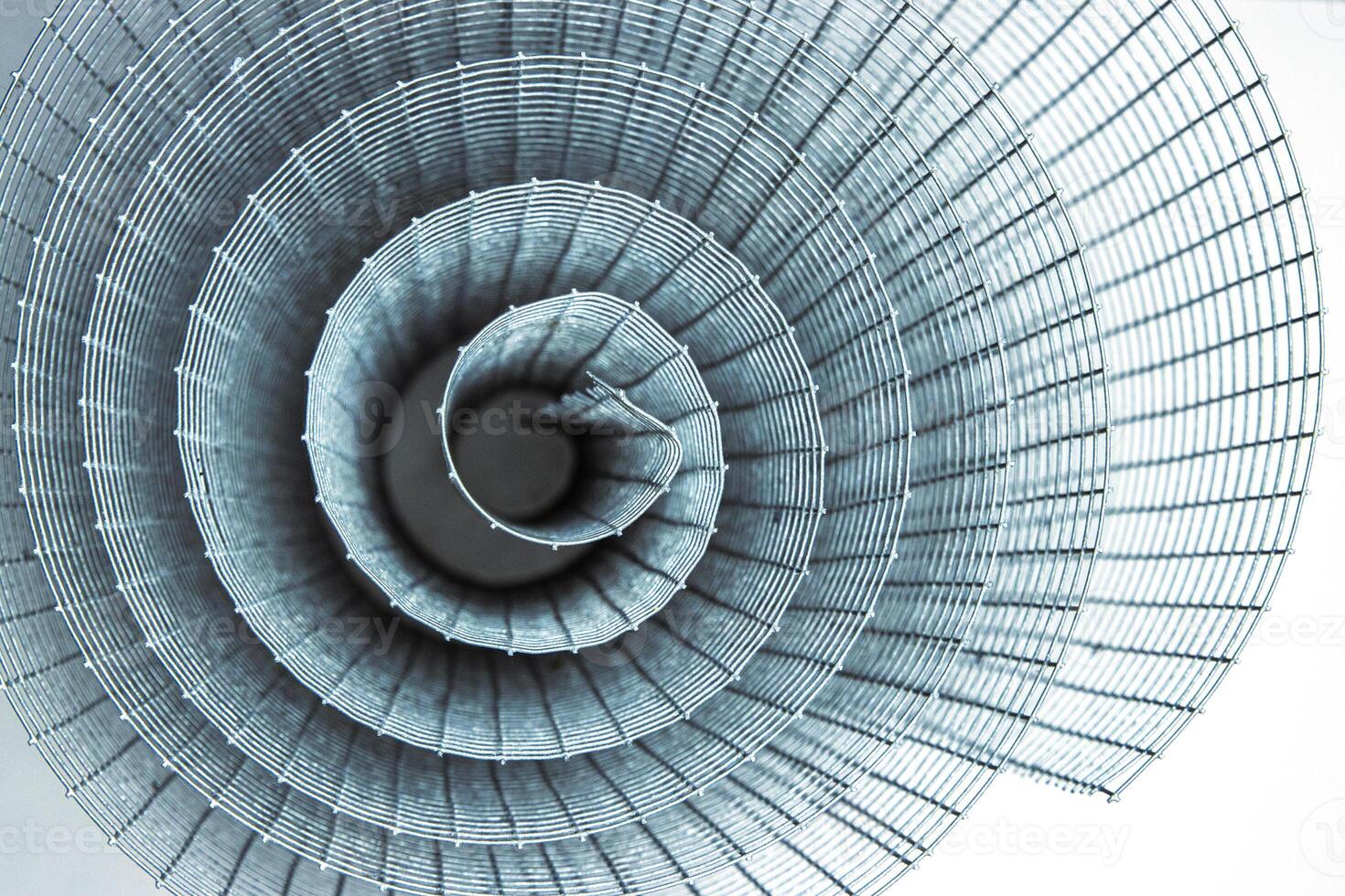Abstract spiral metal coiled wire mesh with grid pattern, geometric symmetry, modern minimal design for industrial construction, diy, architectural concepts. Isolated on white background. Copy space photo