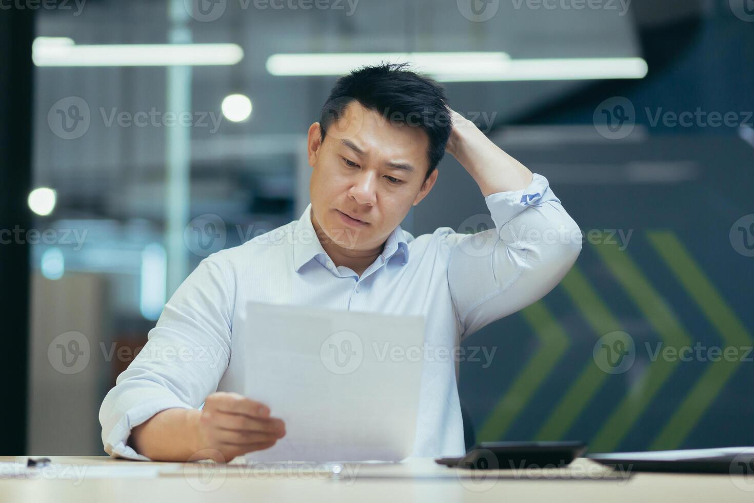 Stressed businessman holding face with his hands because having trouble. Bankrupt Asian Male is sitting with laptop computer and paperwork on desk at workplace in office. Business Mistake Financial photo