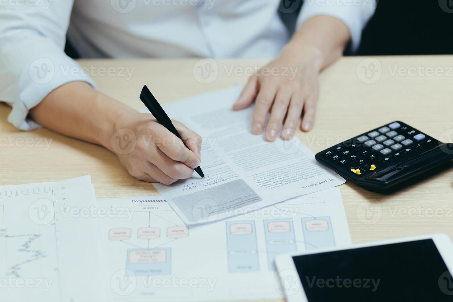 A close-up photo of a businessman's hand working on paperwork, an accountant, a financier, calculates financial statements and sums them up on a calculator