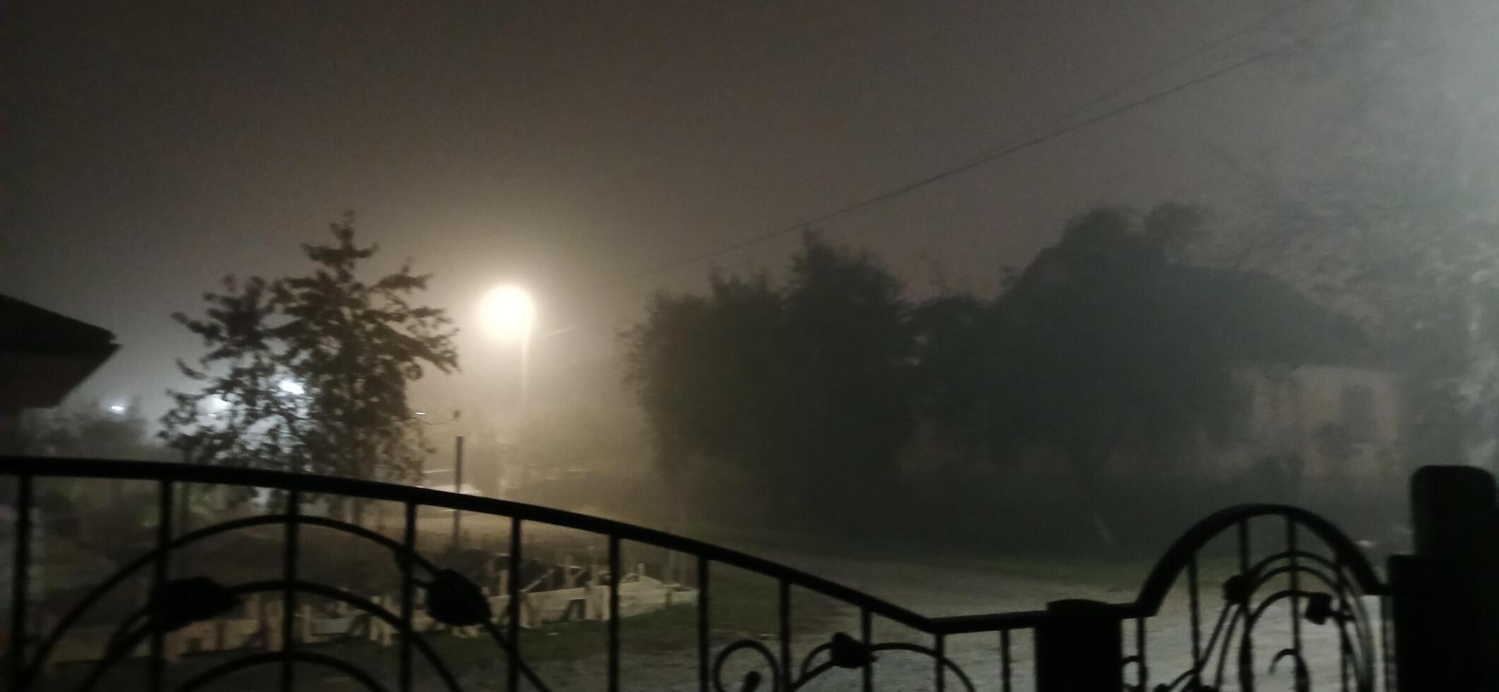 A gate is open at night with a street light photo