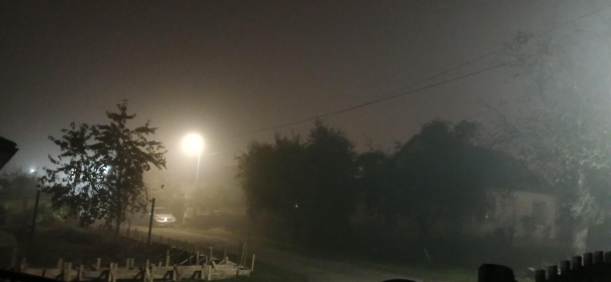A street at night with lights on and fog photo