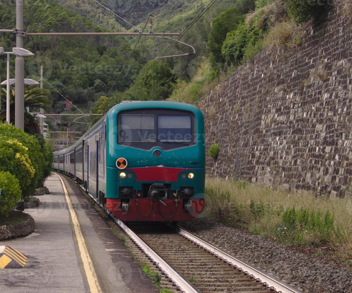 The five lands train is coming at the railstation of Moneglia, Italy. SUmmer 2019. photo
