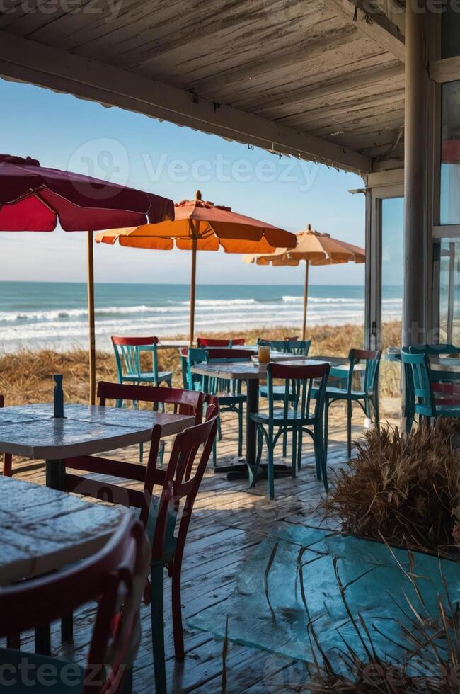 A beachfront caf with colorful umbrellas and tables overlooking the ocean waves. photo