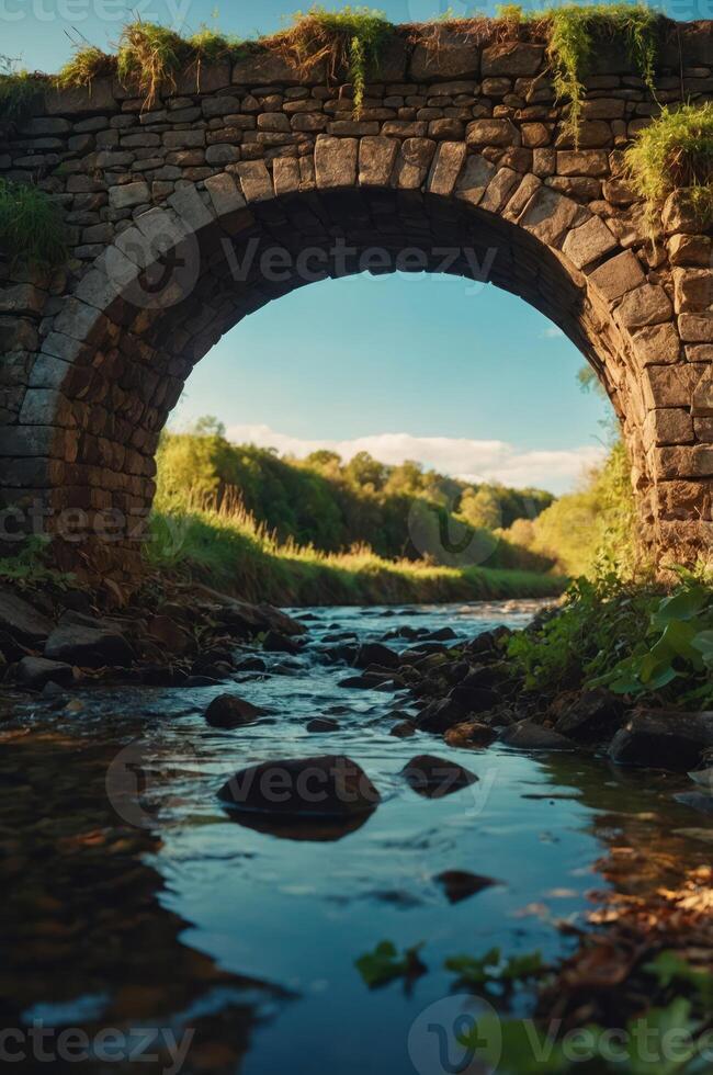 A serene view of a stone bridge arching over a tranquil stream surrounded by lush greenery. photo