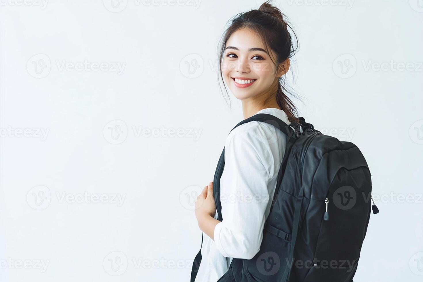A woman with a backpack standing in front of a white background photo