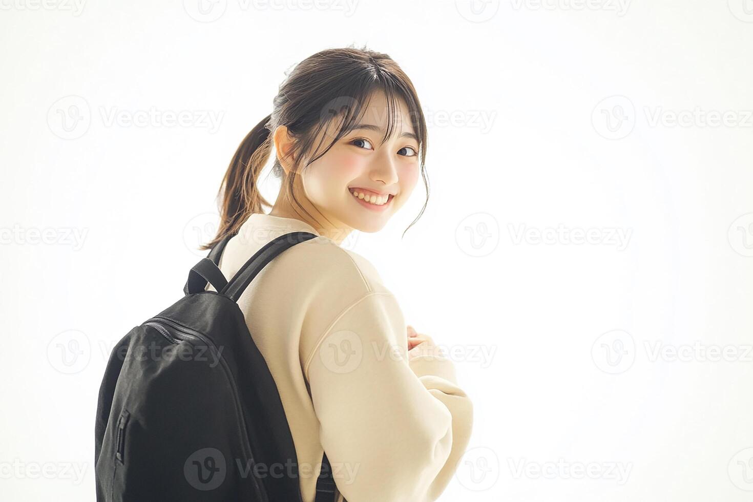 A young woman with a backpack standing in front of a white background photo