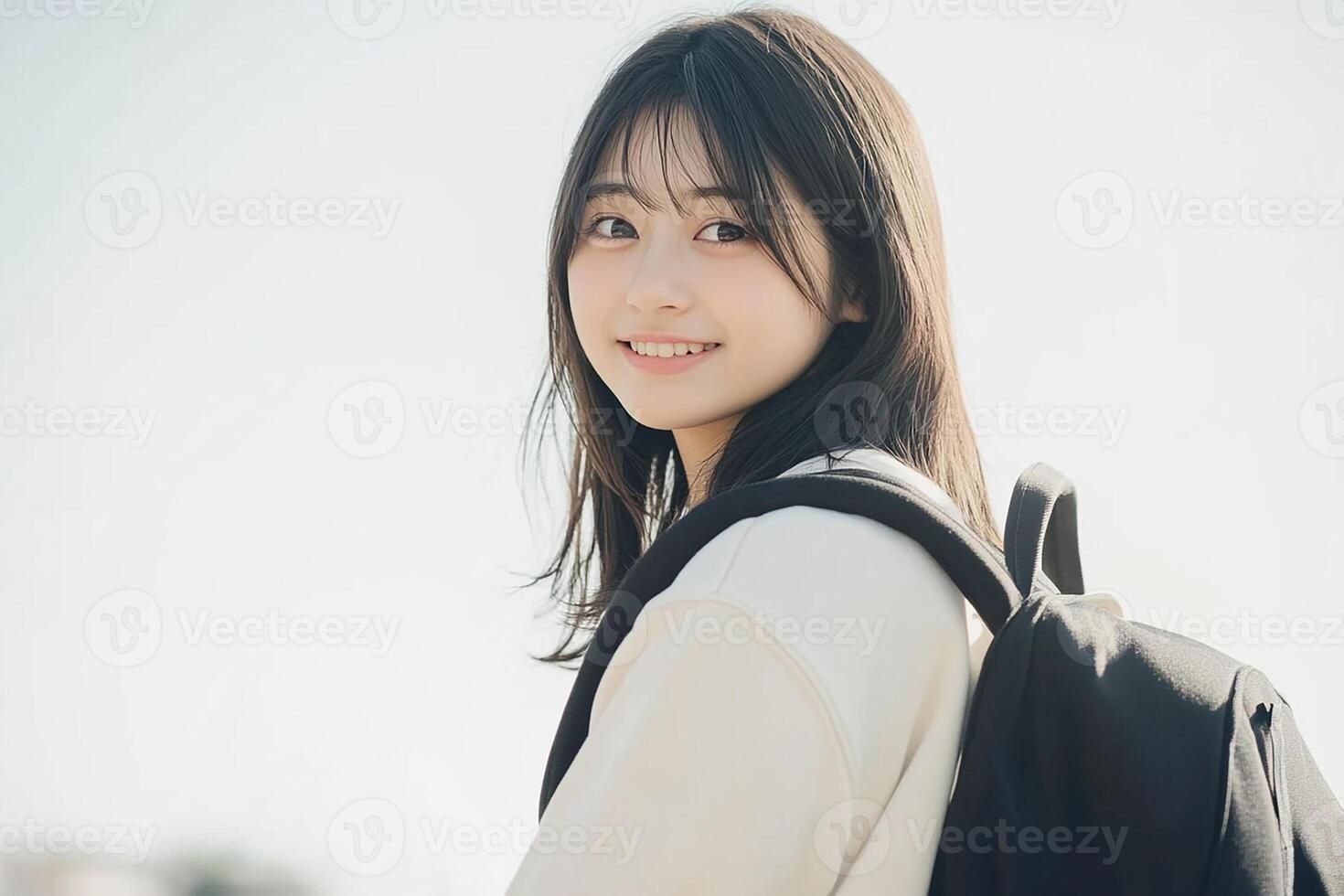 A young woman with a backpack smiles photo