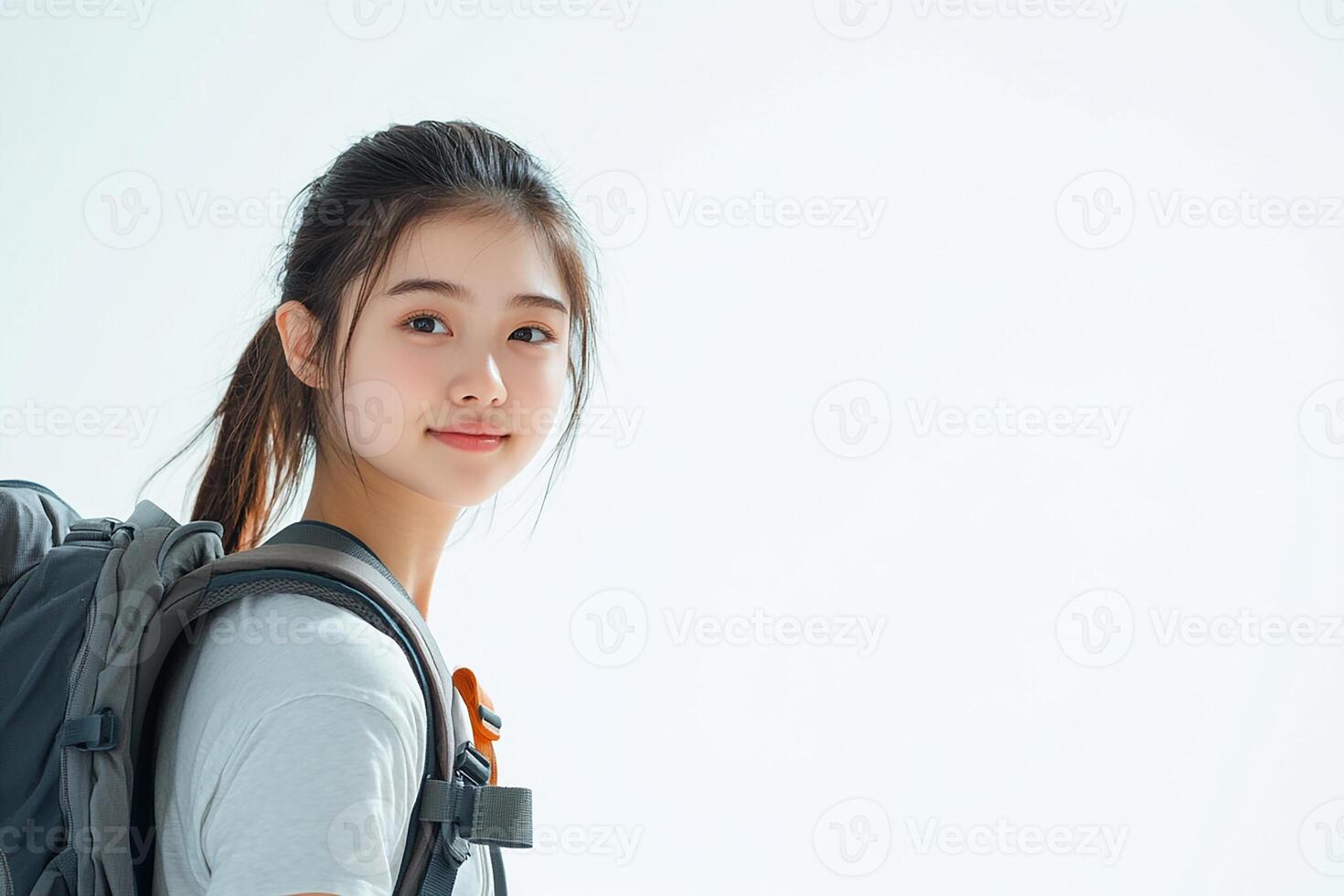 A young woman with a backpack is posing for the camera photo