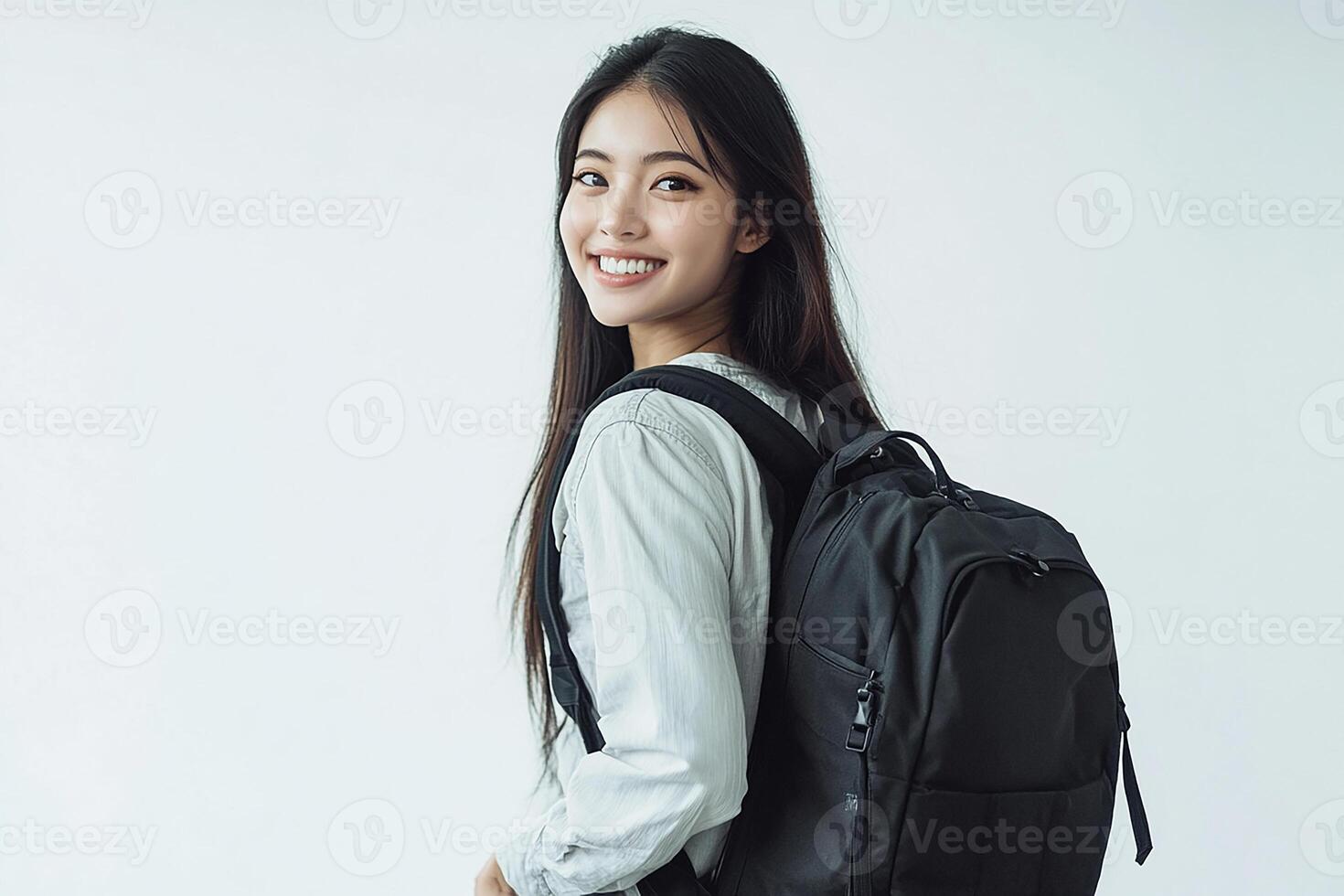 A woman with a backpack standing in front of a white background photo