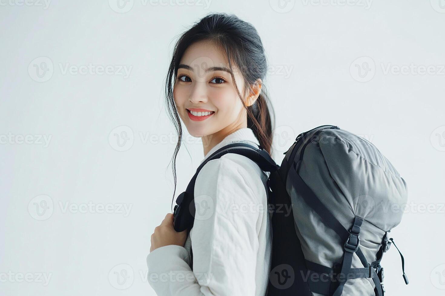 Portrait of young asian woman with backpack on white background photo