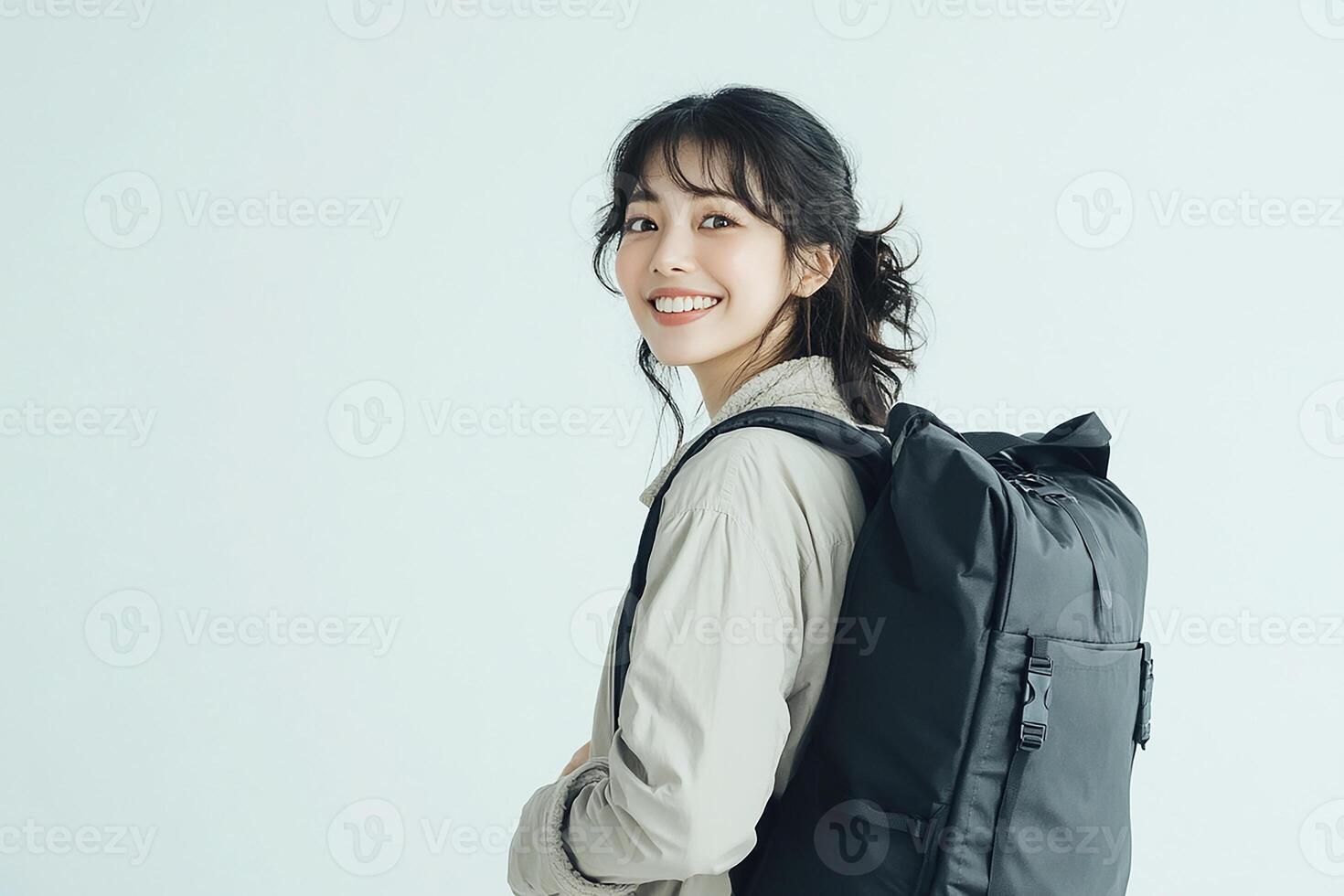 A woman is smiling while holding a black backpack photo