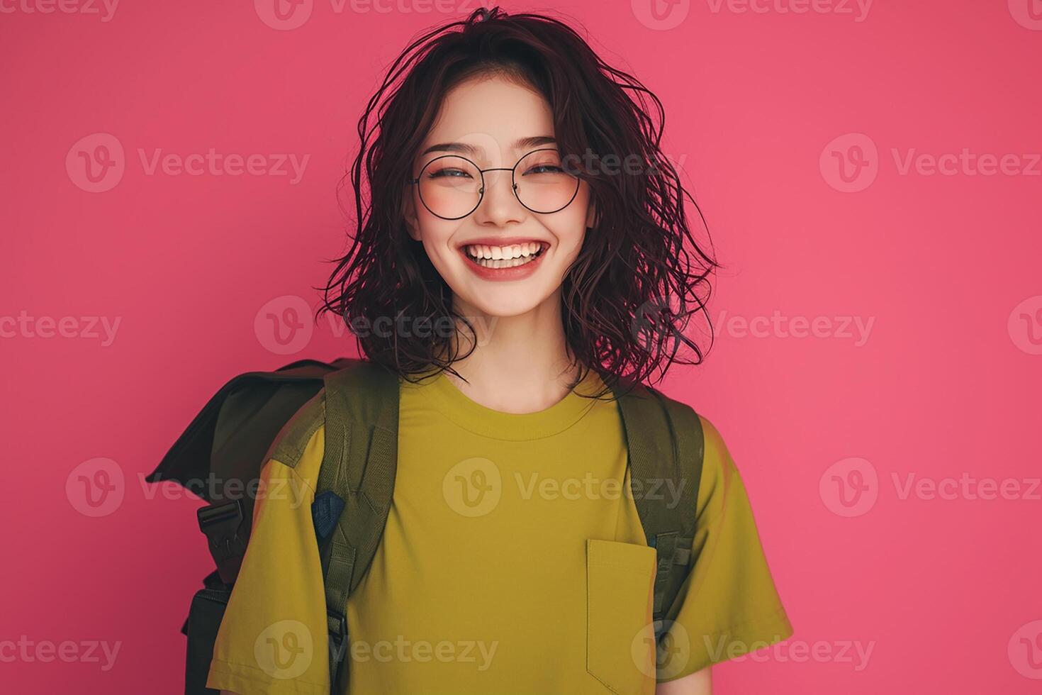 A young woman with glasses and a backpack smiling photo